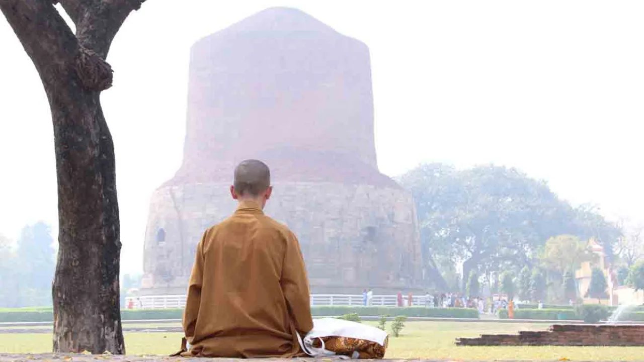 Moine bouddhiste méditant devant le temple de Sarnath, Inde, Oasis