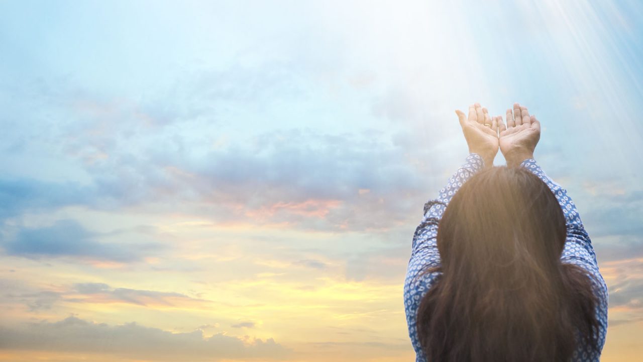 Femme tendant les mains vers le ciel, Oasis