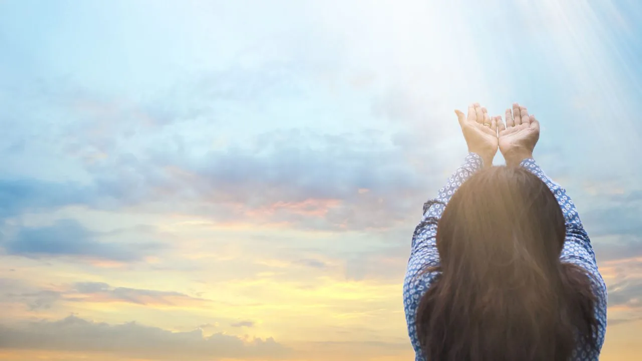 Femme tendant les mains vers le ciel, Oasis